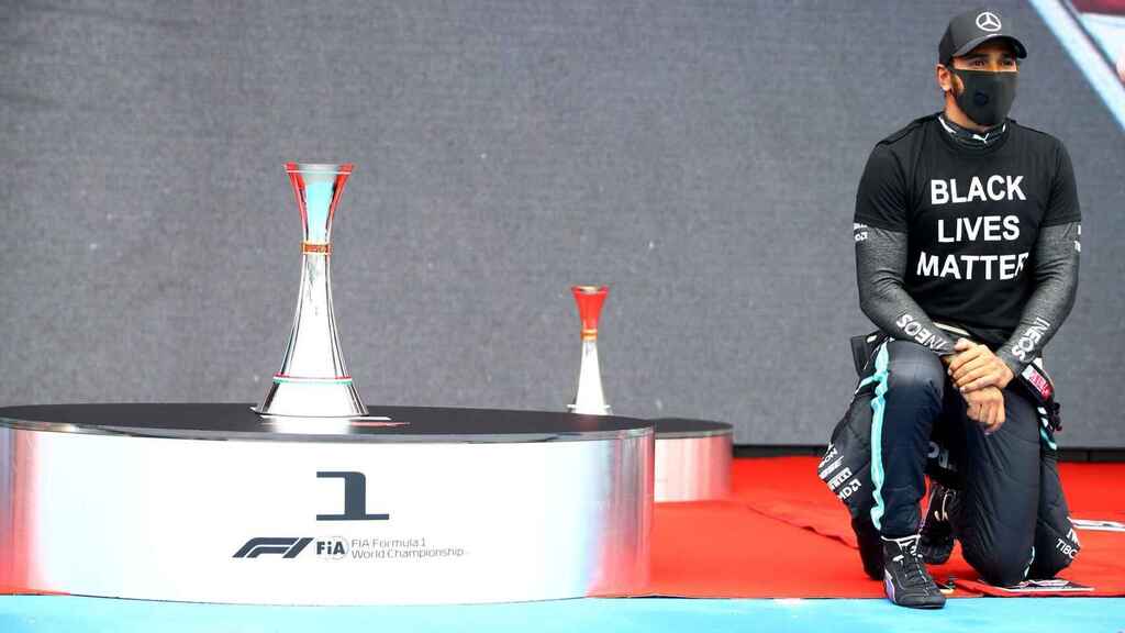 Lewis Hamilton kneels on the podium at the Hungarian Grand Prix.