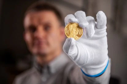 Engraver Thomas T. Docherty displays a gold coin to commemorate the 40th birthday of Prince William of England.