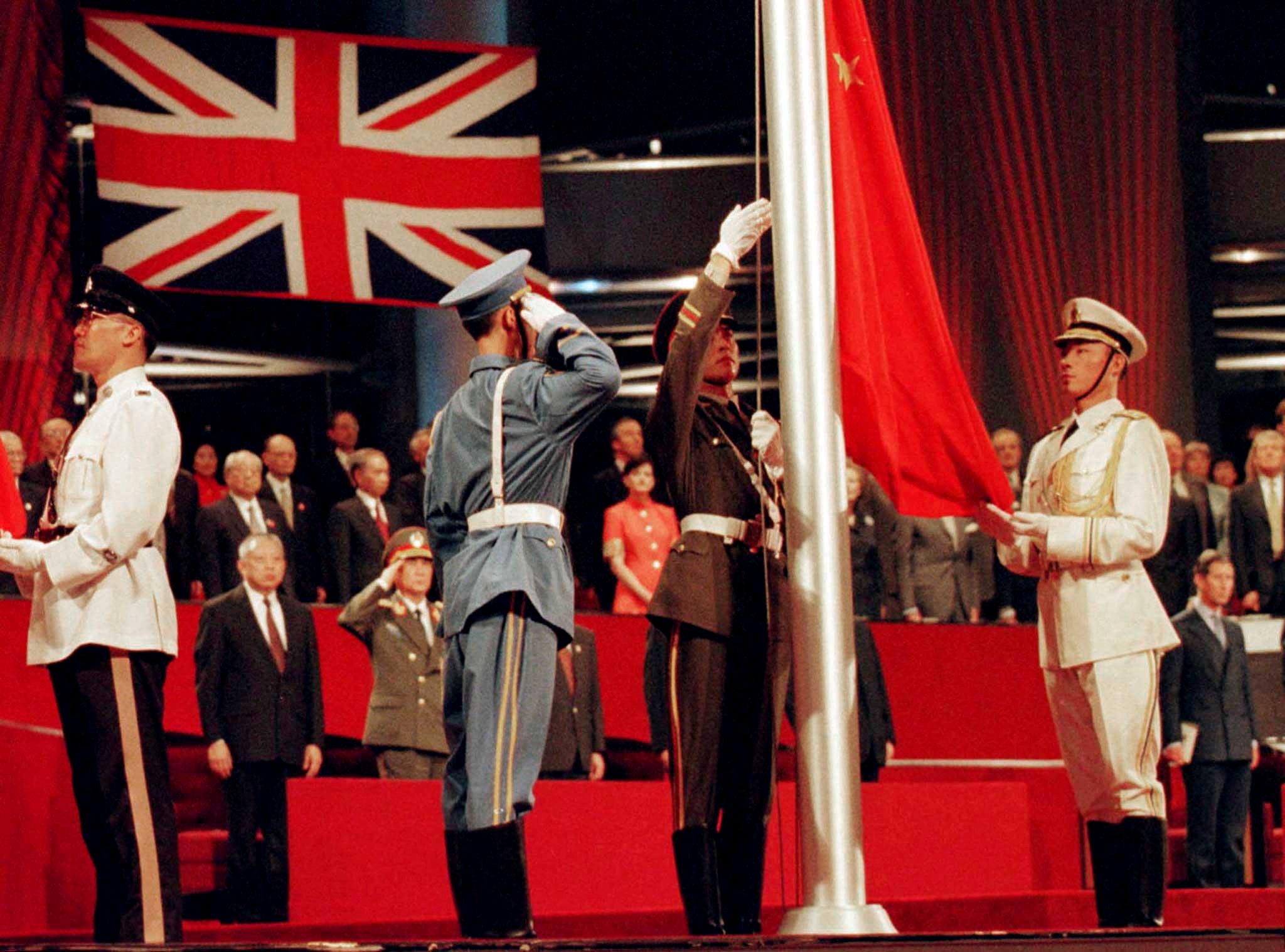 FILE PHOTO: People's Liberation Army soldiers raise the Chinese flag at the handover ceremony in which China regains sovereignty over Hong Kong after 156 years of British colonial rule in Hong Kong on July 1, 1997 (Reuters/Dylan Martinez)