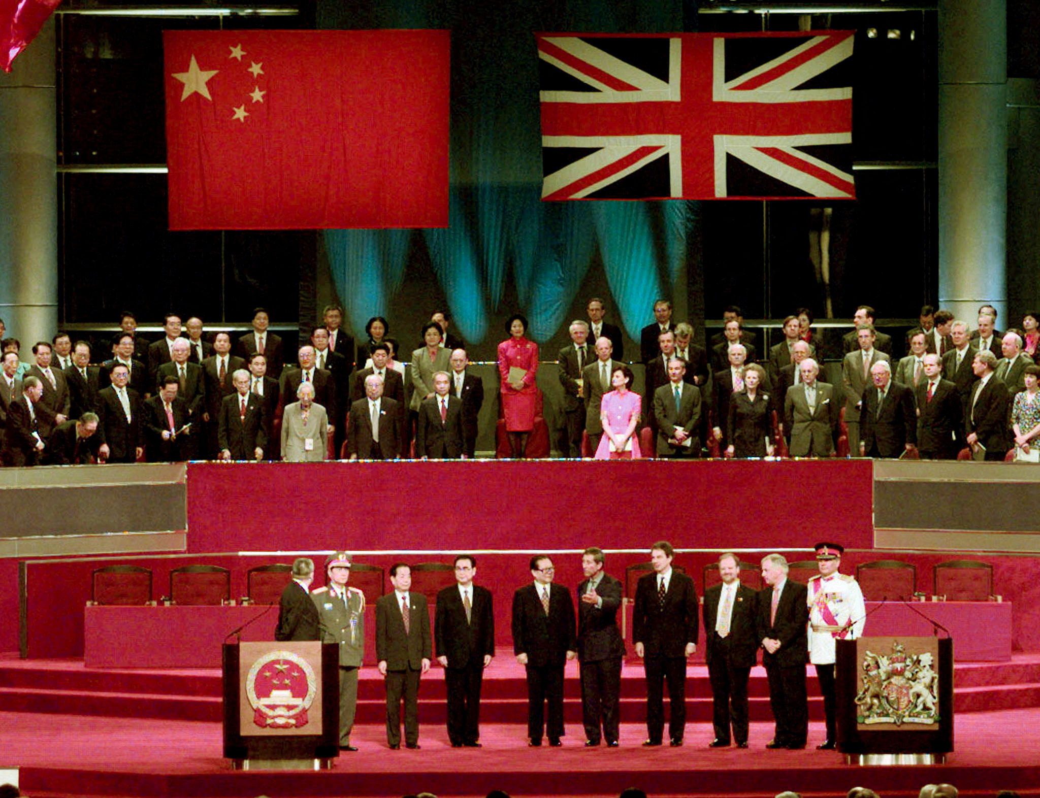 FILE PHOTO: Leaders of China and the United Kingdom stand during the raising of the Chinese flag at the ceremony of transferring sovereignty from Hong Kong to China after 156 years of British rule, on July 1, 1997 (REUTERS/Jason Red)