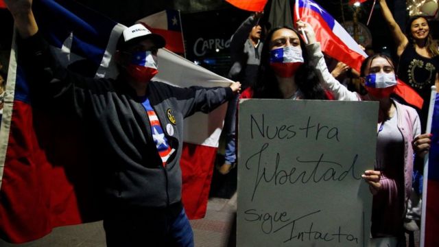 Citizens celebrate the result of the rejection of Chile's new constitution proposal with a poster that says "Our freedom is still intact".